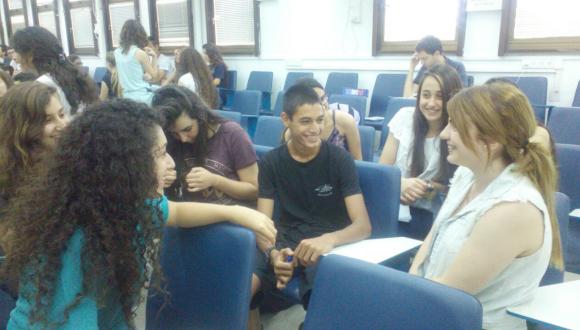 בוגרי אוניברסיטת קיץ לנוער משוחחים עם תלמידים צעירים